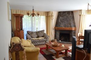 sala de estar con sofá y chimenea en Departamento Pucon, en Pucón