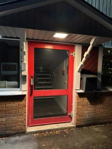 una porta rossa su un edificio con finestra di Frövi vandrarhem a Frövi