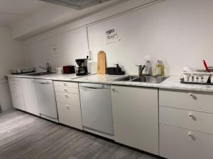 una cucina con mobili bianchi e un lavandino di Frövi vandrarhem a Frövi