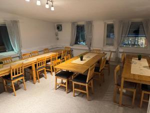 una sala da pranzo con tavoli e sedie in legno di Frövi vandrarhem a Frövi