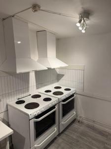 una cucina con piano cottura bianco e cappa bianca di Frövi vandrarhem a Frövi