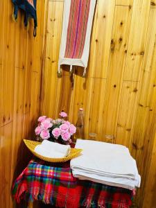 a table with a basket of flowers and towels at Lee's Charm Homestay in Sa Pa