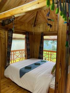a large bed in a wooden room with windows at Lee's Charm Homestay in Sa Pa