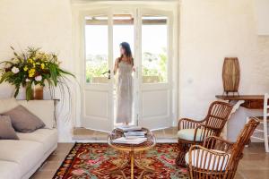 a woman standing at a door in a living room at Masseria del Gigante in Carpignano Salentino