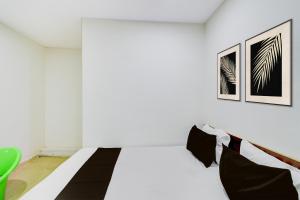 een witte kamer met een bed en een groene stoel bij Hotel O S V Residency in Vidya Nagar