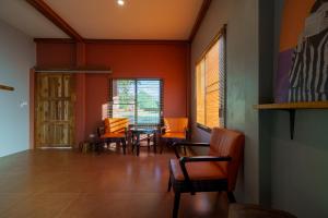 una sala da pranzo con tavolo e sedie arancioni di Bricks & Bed house pai a Ban Wiang Nua