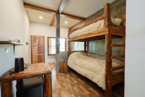 a bedroom with a bunk bed and a desk at Bricks & Bed house pai in Ban Wiang Nua