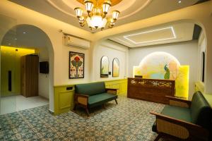 a waiting room with a green couch and a chair at Hotel Indiana Hitech City in Hyderabad