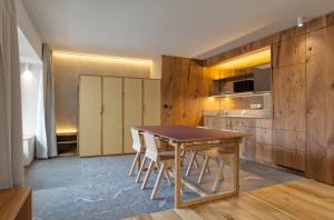 una cucina e una sala da pranzo con tavolo e sedie in legno di Sarti Apparment a San Candido