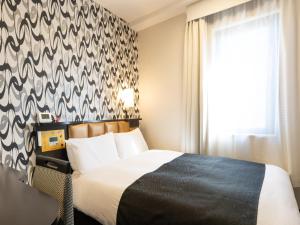 Ένα ή περισσότερα κρεβάτια σε δωμάτιο στο APA Hotel STAY Toyama