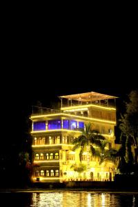a building with blue lights on it at night at The Lake Haveli in Udaipur