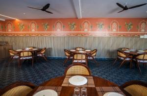 a dining room with wooden tables and chairs at Hotel Indiana Hitech City in Hyderabad