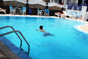 a person swimming in a large swimming pool at Samson΄s Village in Perissa