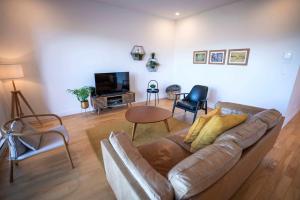 een woonkamer met een bank en een televisie bij 309 - Luxury Condo - Spectacular View & Pool in Baie-Saint-Paul +50 foto's