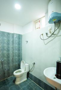 a bathroom with a toilet and a sink at Hotel Indiana Hitech City in Hyderabad +105 photos