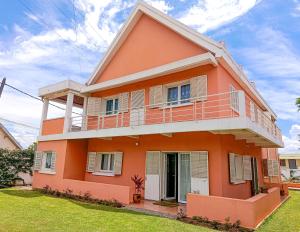 a orange house with a green yard at Maison Hely Tiana in Antananarivo