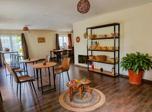 a living room with tables and chairs and a table at Maison Hely Tiana in Antananarivo