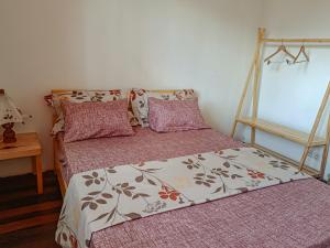 a bedroom with two beds with pink sheets and a table at Maison Hely Tiana in Antananarivo