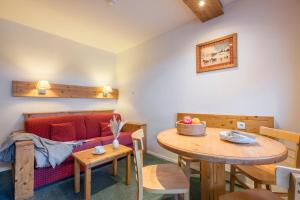 a living room with a table and a couch at Résidence Pierre & Vacances Le Peillon in Méribel