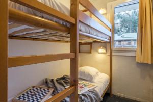 a bedroom with two bunk beds and a window at Résidence Pierre & Vacances Le Peillon in Méribel