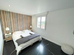 a white bedroom with a bed and a window at Atypaluxe Appartement 3 chambres in Épinal