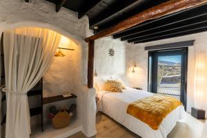 a bedroom with a bed and a large window at La Geria Suites in Yaiza +85 photos