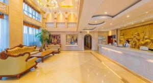 um saguão com sofás e uma área de espera em um prédio em Yichang Vienna Hotel Wanda Branch em Yichang