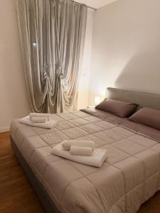 een slaapkamer met een groot bed met twee handdoeken erop bij Rose e Frutta - Silver Moon in Monfalcone