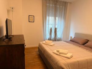 a bedroom with a bed with two towels on it at Rose e Frutta - Silver Moon in Monfalcone