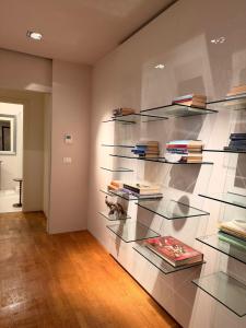 een kamer met glazen planken vol boeken bij Rose e Frutta - Silver Moon in Monfalcone