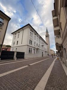 een verlaten straat met een wit gebouw en een klokkentoren bij Rose e Frutta - Silver Moon in Monfalcone