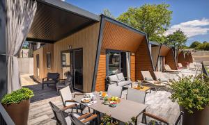 an outdoor patio with a table and chairs at Aminess Style Camping Atea Glamping & Holiday Homes in Njivice