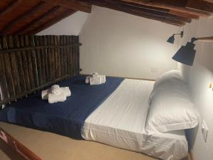 een slaapkamer met een bed met handdoeken erop bij Luxar Suites & Apartments in Assemini