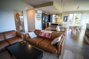 een woonkamer met een bank en een tafel bij 311 - Luxury Condo The 5 Senses - View Pool & EV in Baie-Saint-Paul +52 foto's