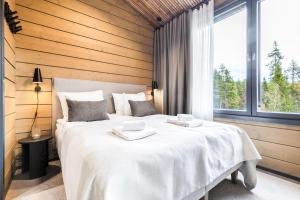 un grande letto bianco in una stanza con una finestra di Levin Lyhty Dawn D4 by Hilla Villas a Kittilä
