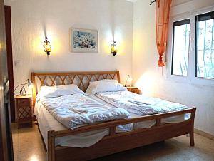 een bed in een slaapkamer met 2 lampen aan de muur bij Calypso in Jávea