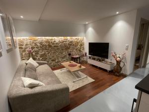 a living room with a couch and a tv at Les Rives du vignoble in Ingersheim