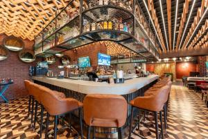 un bar in un ristorante con sedie marroni di Oaks Ibn Battuta Gate Dubai a Dubai