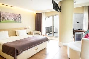 een slaapkamer met een bed en een stoel in een kamer bij Taba Luxury Suites and Hotel in Istanbul