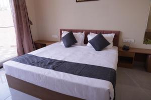 a bedroom with a large bed with two pillows at The Rukmani villas in Jāmb