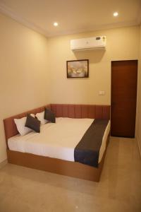 a bedroom with a bed and a air conditioner at The Rukmani villas in Jāmb