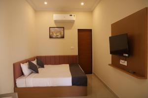 a hotel room with a bed and a television at The Rukmani villas in Jāmb