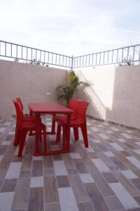 a red table and two chairs on a patio at The Rukmani villas in Jāmb