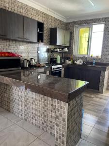 a kitchen with a tile backsplash and a counter top at Goodlifehomes in Mtwapa