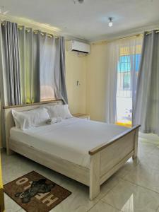 a large bed in a room with a window at Goodlifehomes in Mtwapa