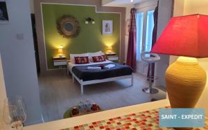 a bedroom with a bed and a red lamp at Bernadette' Cosy Flat - 3 minutes walk main door to sanctuary entrance- Old Town - Bernadette de Soubirous's neighborhood - Chapel for Prayer on site in Lourdes