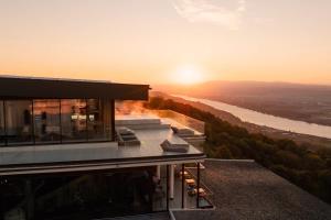a house on a hill with the sunset in the background at Hotel Schachner in Maria Taferl