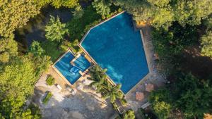 uitzicht op een groot zwembad met bomen bij Comsaed River Kwai Resort in Kanchanaburi