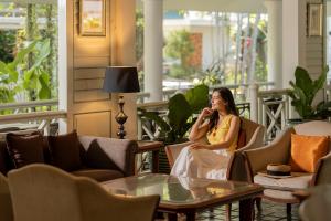a woman sitting on a porch talking on a cell phone at Comsaed River Kwai Resort in Kanchanaburi City +42 photos