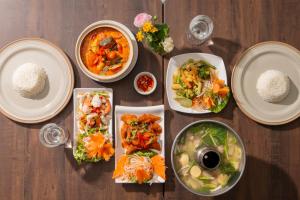 a table with plates of food and rice on it at Comsaed River Kwai Resort in Kanchanaburi City